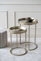 Antique gold side tables with glass tops in a stylish living room setting.