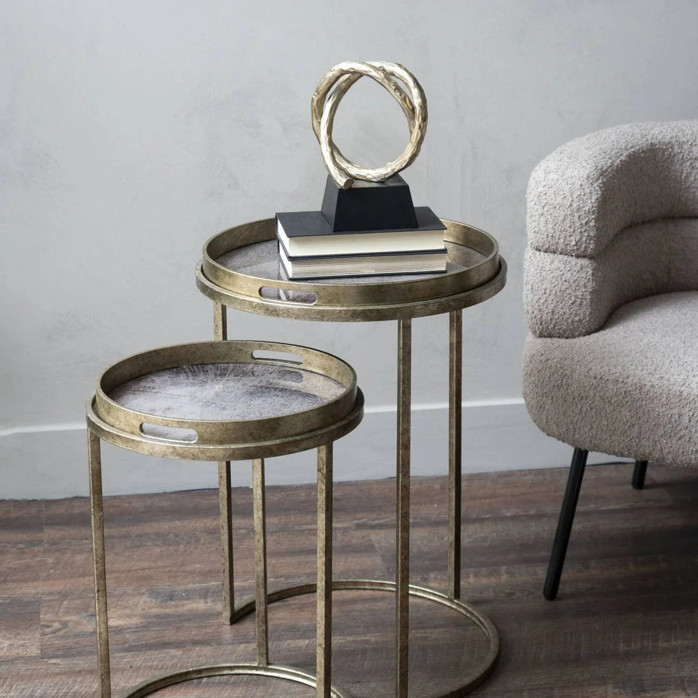 Antique gold tray tables in a cozy living room with a decorative sculpture.