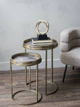 Antique gold tray tables in a cozy living room with a decorative sculpture.