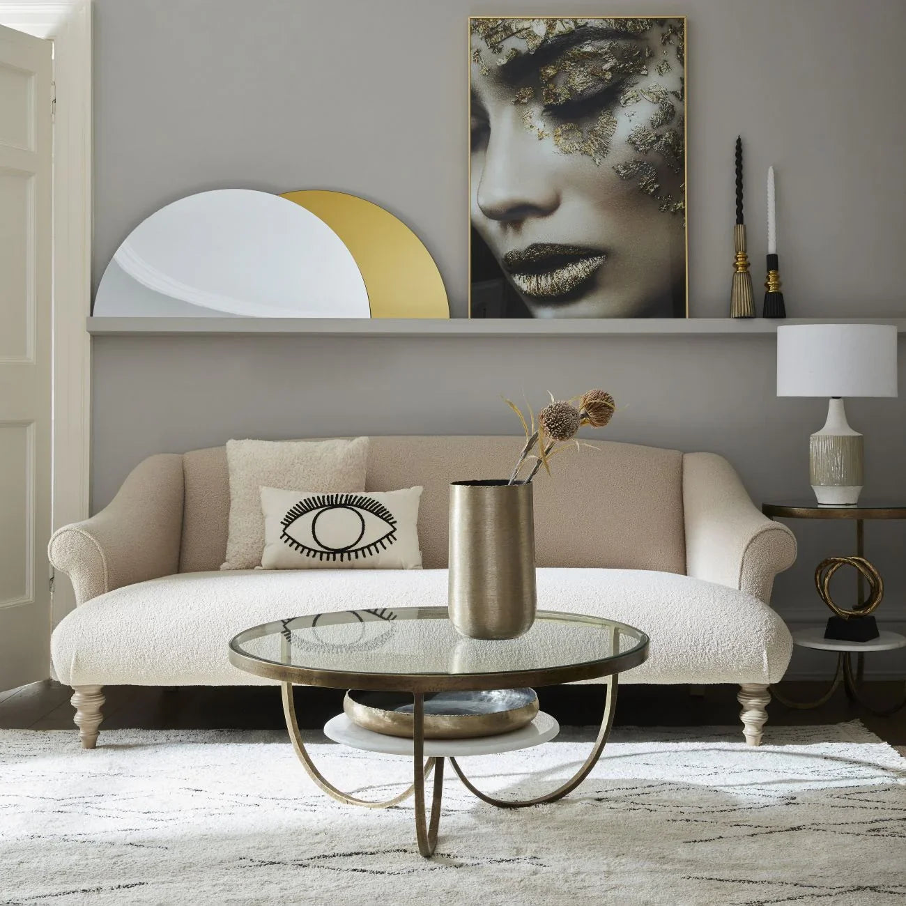 Round marble and gold coffee table in elegant living room setting.