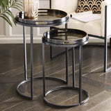 Black metal side tables with intricate tray tops in a modern living room setting.