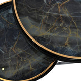 Black and gold tray tables with marbled surface detail.