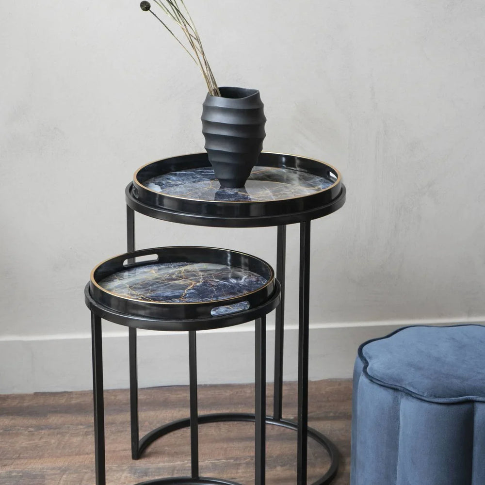 Black and gold side tables with marble tops, styled with a black vase.