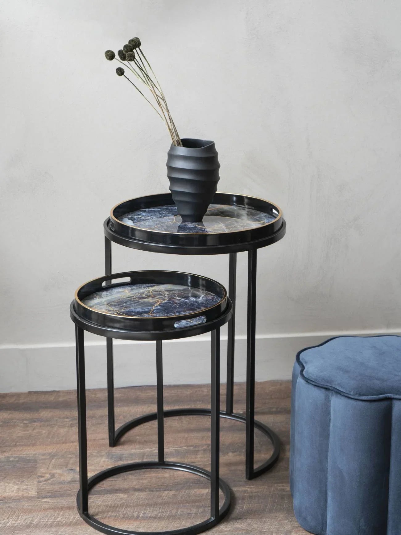 Black and gold side tables with marble tops, styled with a black vase.