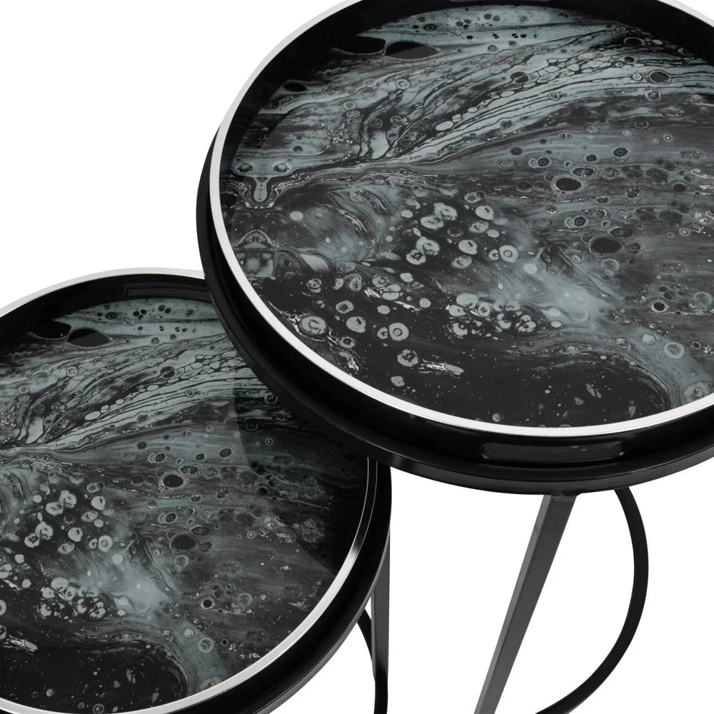 Black and white tray tables with swirling marble pattern tops.