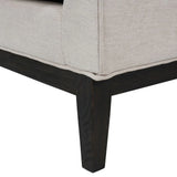 Ivory fabric armchair corner with dark wooden leg detail.