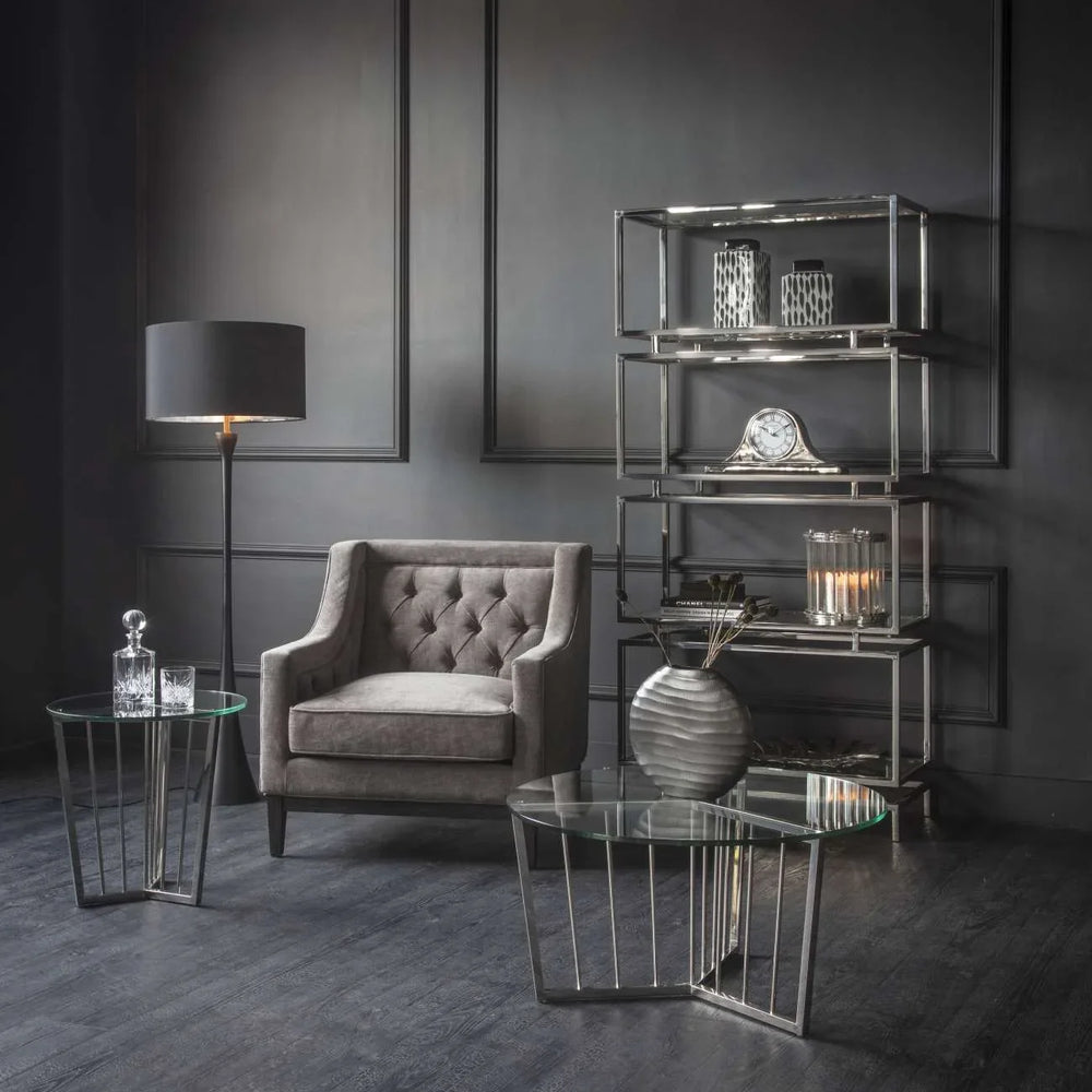 Warm grey armchair in elegant living room with glass tables and modern decor.