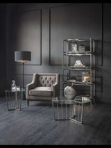 Warm grey armchair in elegant living room with glass tables and modern decor.