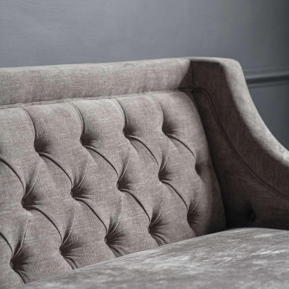 Warm grey sofa with buttoned backrest and textured fabric.