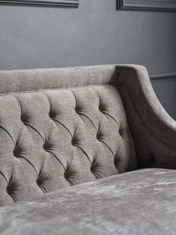 Warm grey sofa with buttoned backrest and textured fabric.