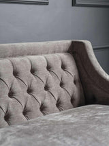 Warm grey sofa with buttoned backrest and textured fabric.