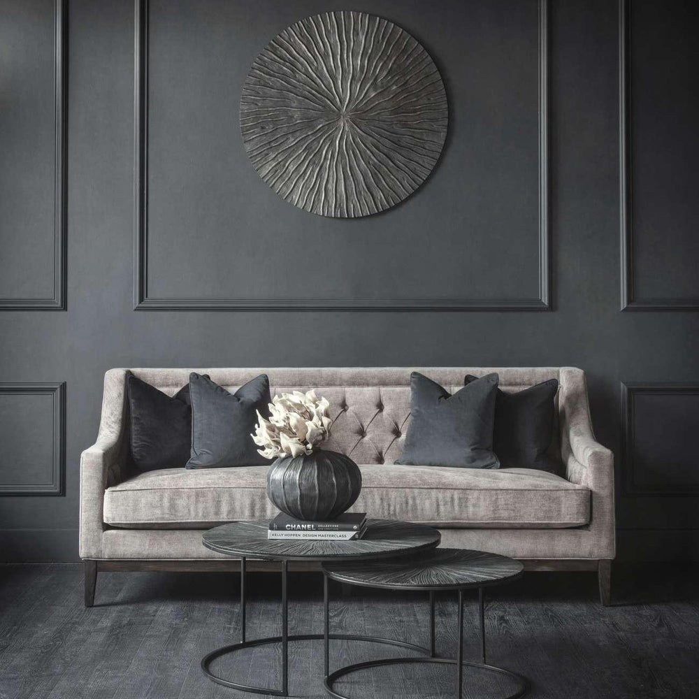 Warm grey sofa with dark cushions in an elegant living room setting.