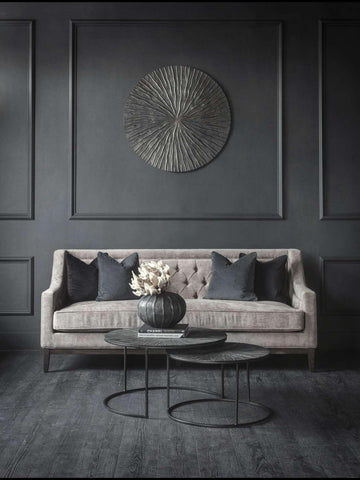 Warm grey sofa with dark cushions in an elegant living room setting.