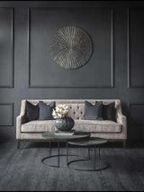 Warm grey sofa with dark cushions in an elegant living room setting.