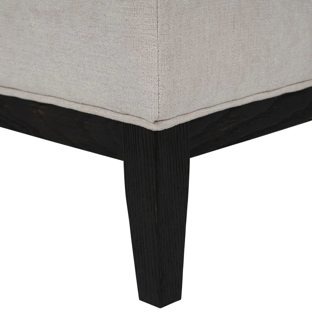 Ivory fabric stool corner with dark wooden leg detail
