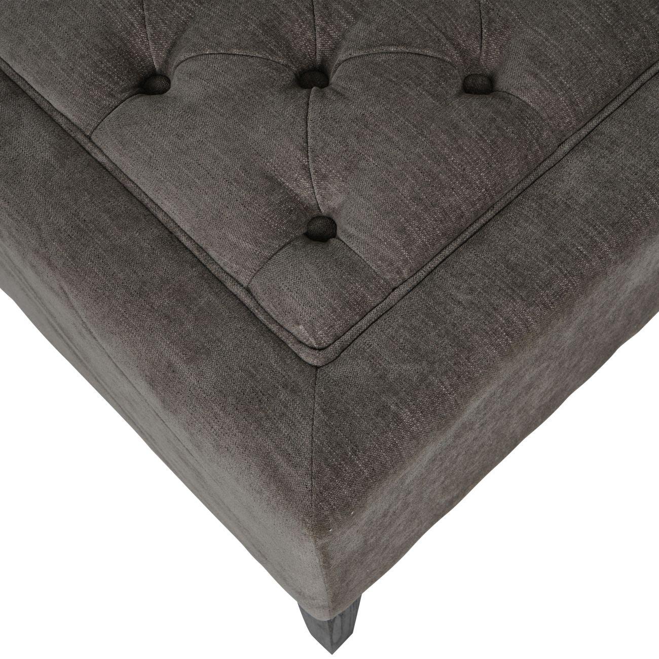 Warm grey fabric stool with button-tufted detail and textured surface.