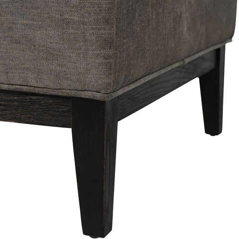 Warm grey fabric stool corner with dark wooden legs.