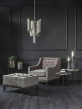Warm grey buttoned stool in elegant dark living room with armchair and pendant light.