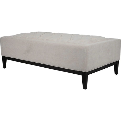 Ivory fabric ottoman with buttoned top and dark wooden legs.