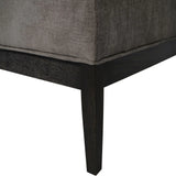 Dark wood leg of grey fabric ottoman showing corner detail.