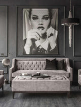 Warm grey ottoman in elegant living room with tufted sofa and modern decor.