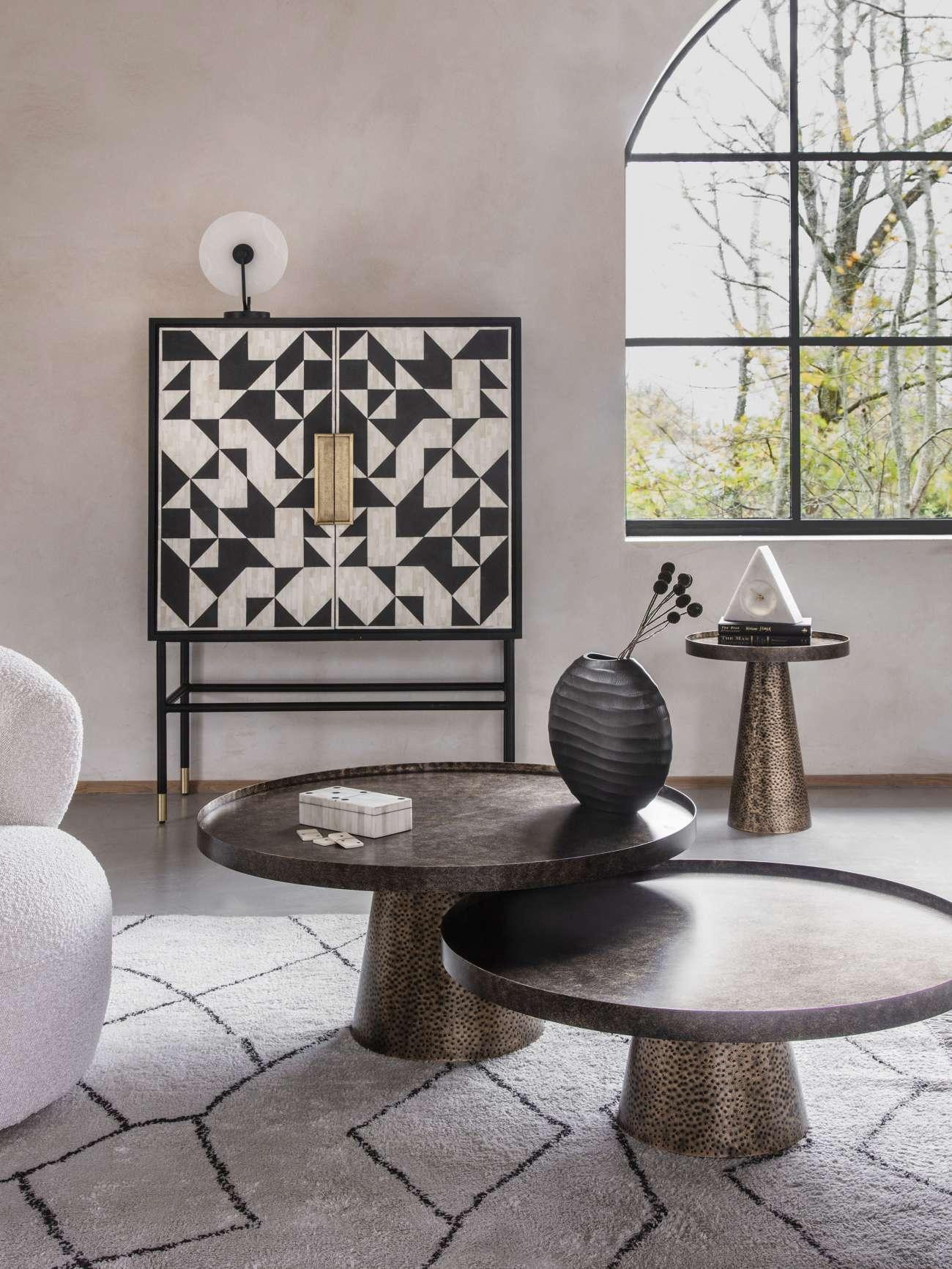Rustic antique gold side table with textured finish in modern living room setting.