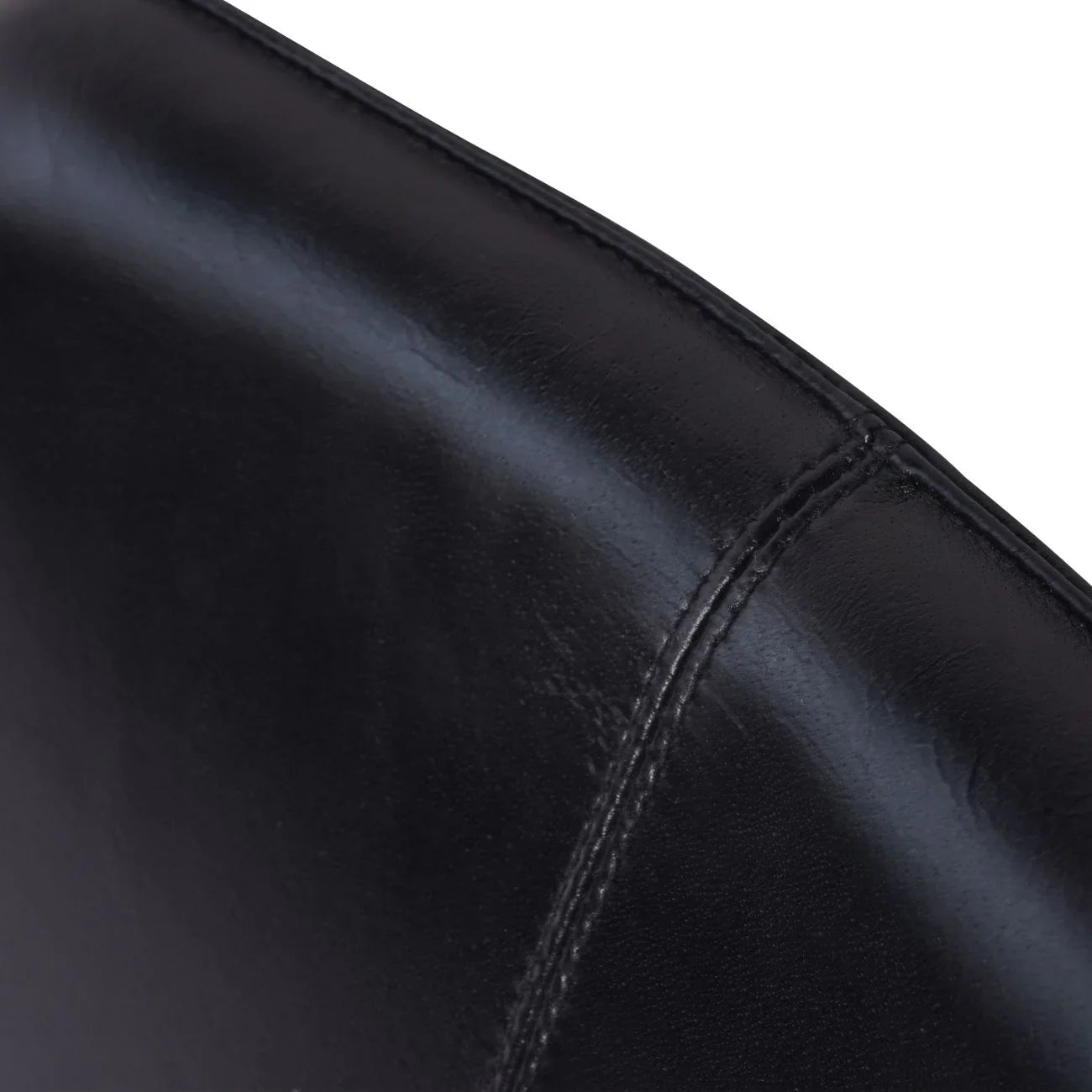 Charcoal leather chair back with detailed stitching.