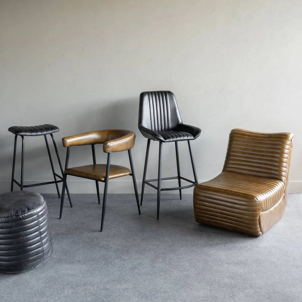 Charcoal leather bar stool with ribbed backrest in modern room setting.