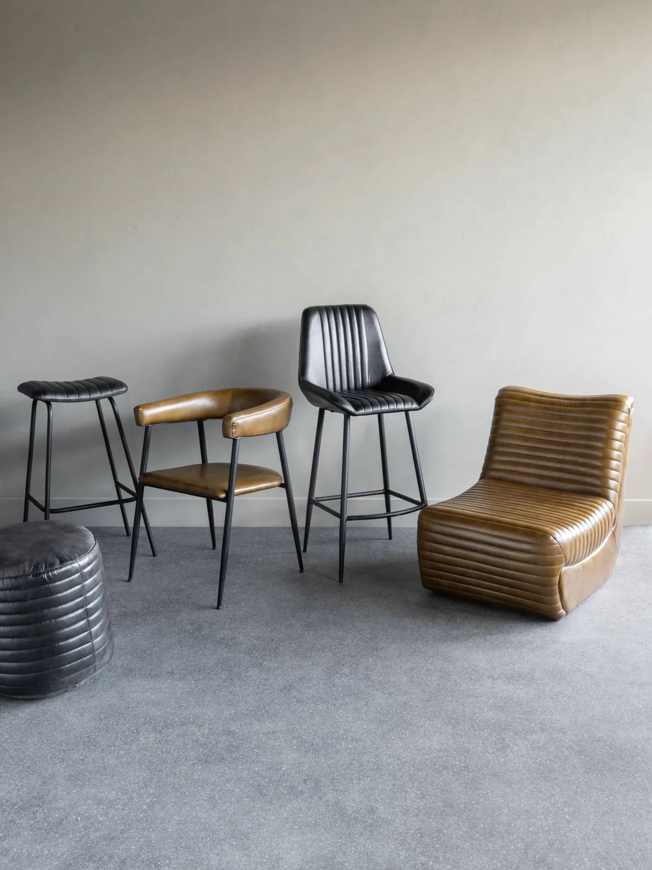 Charcoal leather bar stool with ribbed backrest in modern room setting.