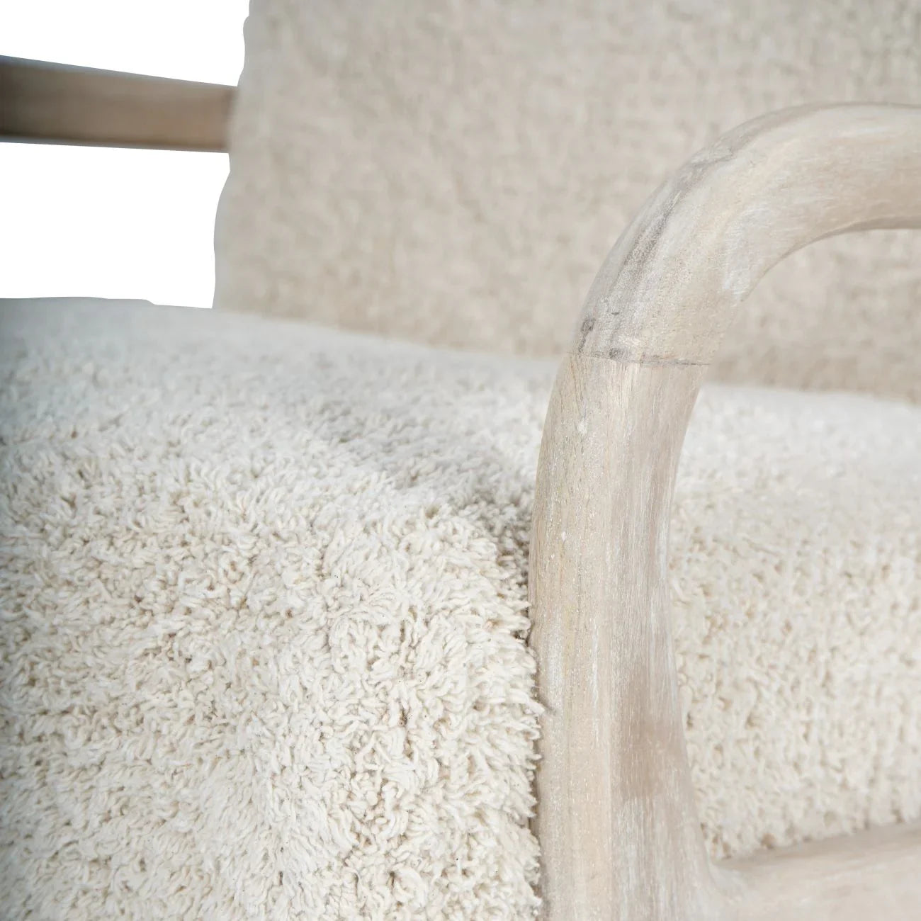 Cream textured chair with curved wooden armrest detail.