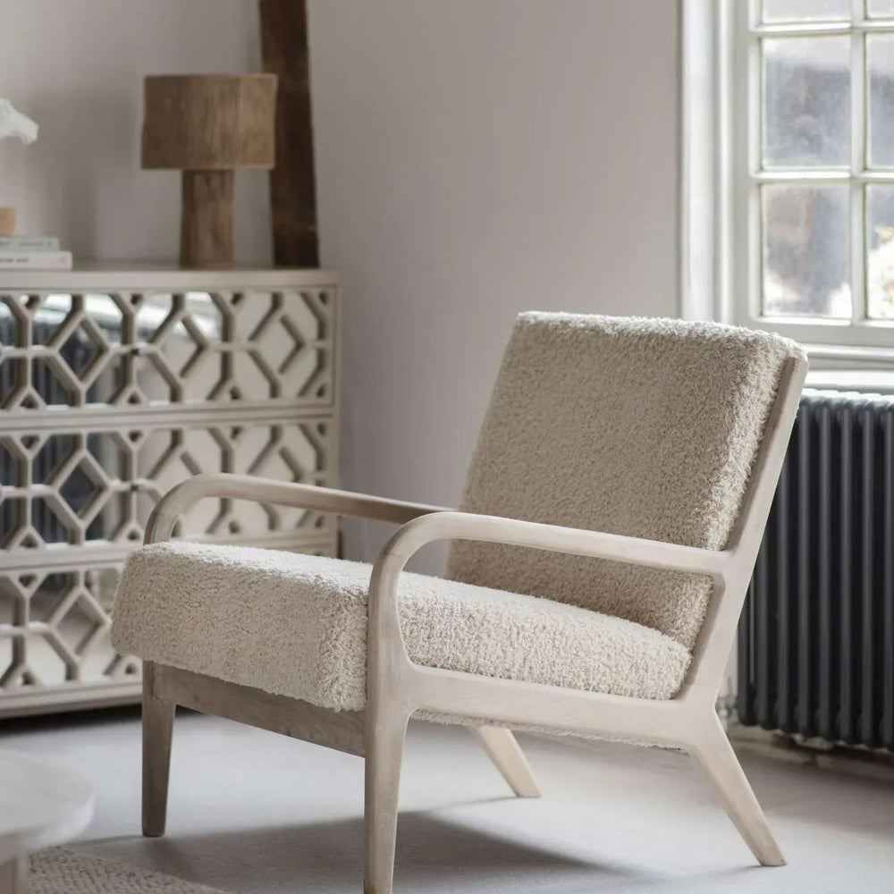 Cream textured chair with wooden frame in a cozy living room setting.