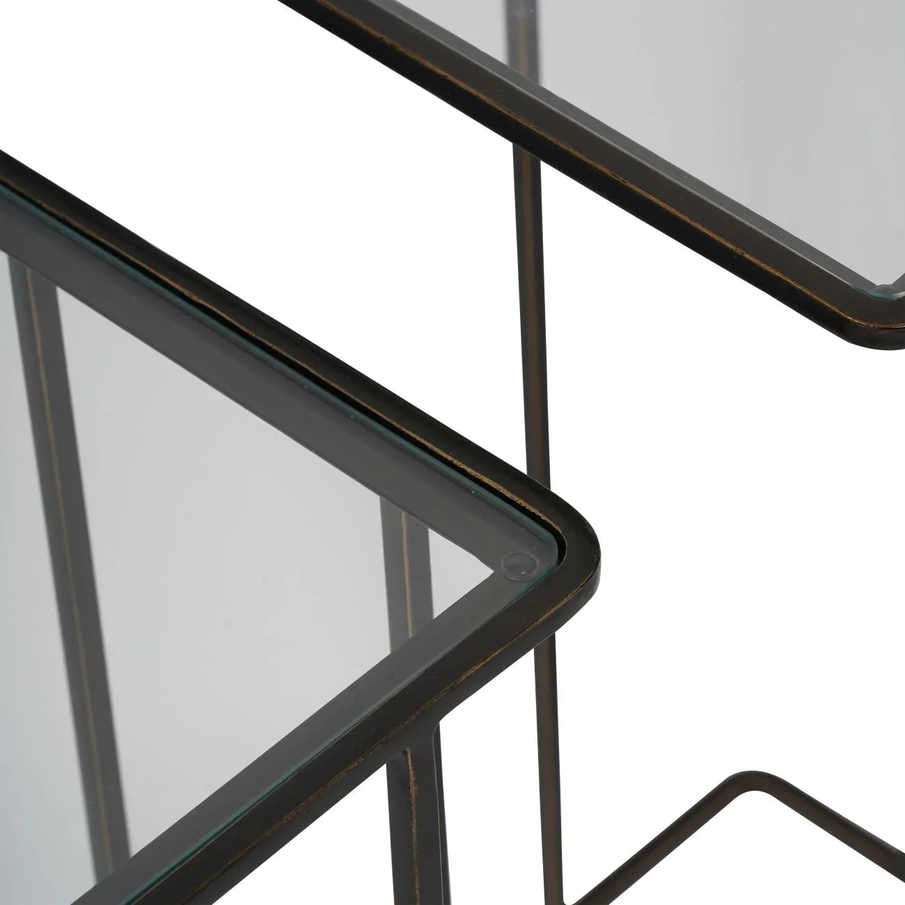 Dark bronze side tables with glass tops, corner detail.