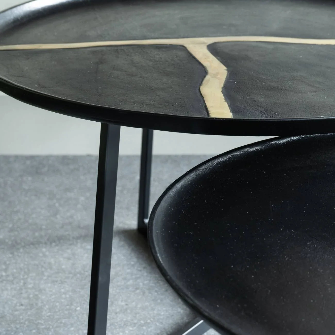 Black aluminium coffee tables with textured surfaces and unique design accents.