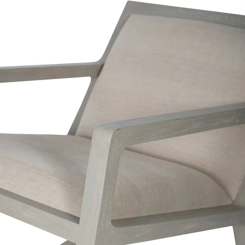 Beige cushioned chair with light wood frame detailing