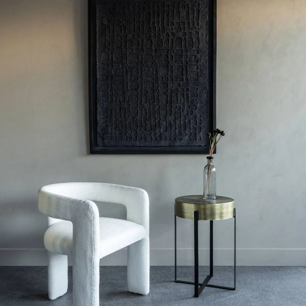 Ivory slub chair in modern room with textured artwork and a small side table.