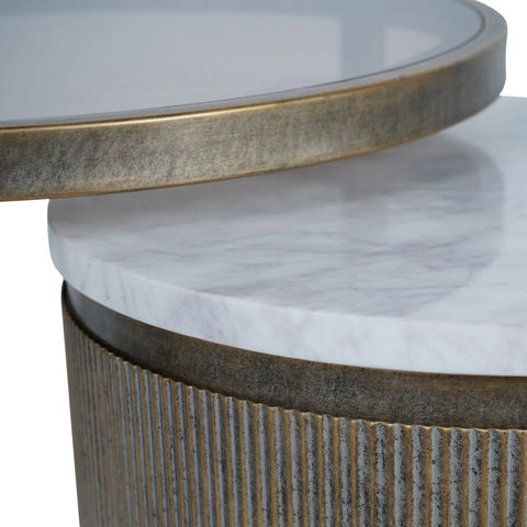 Aged gold nesting tables with marble tops and ribbed metal edges.