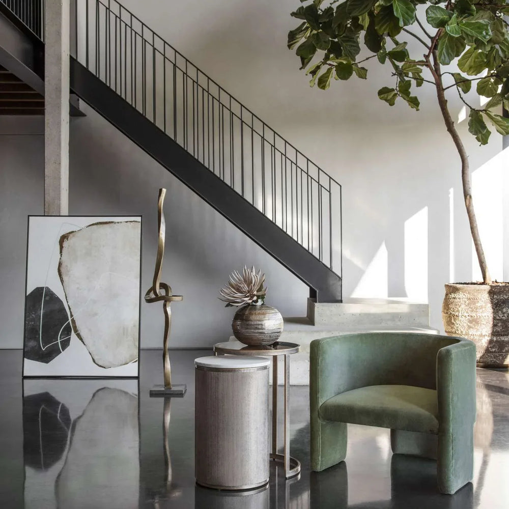 Nesting tables in a modern room with green chair and abstract art.