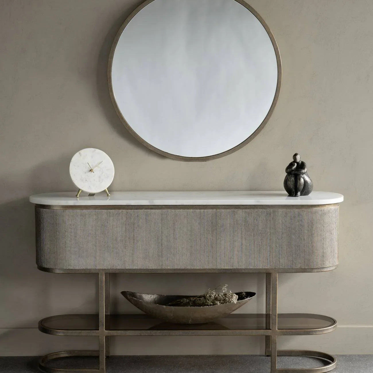 Aged gold console with a shelf, styled with a round mirror and decorative items.