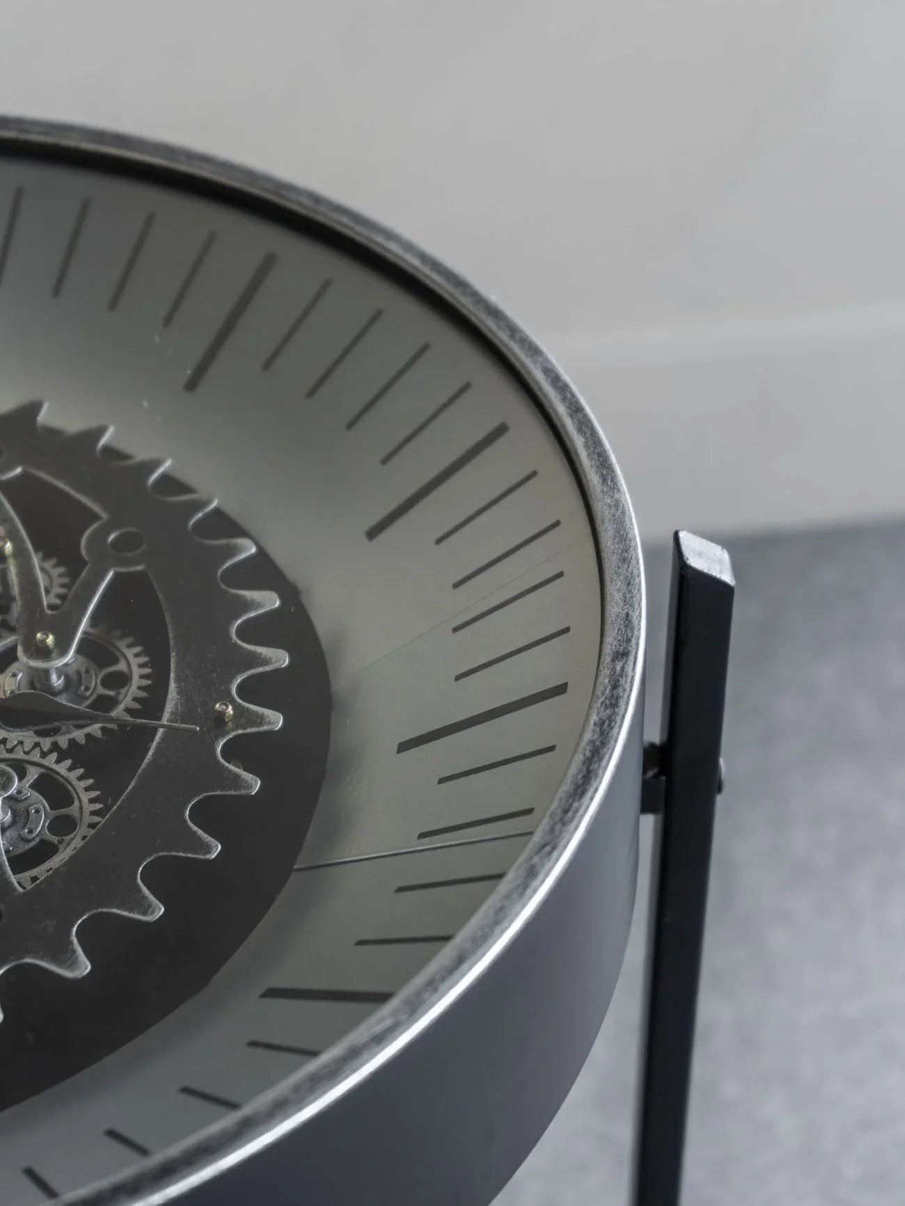 Black nickel table clock with visible moving cogs and sleek dial design.