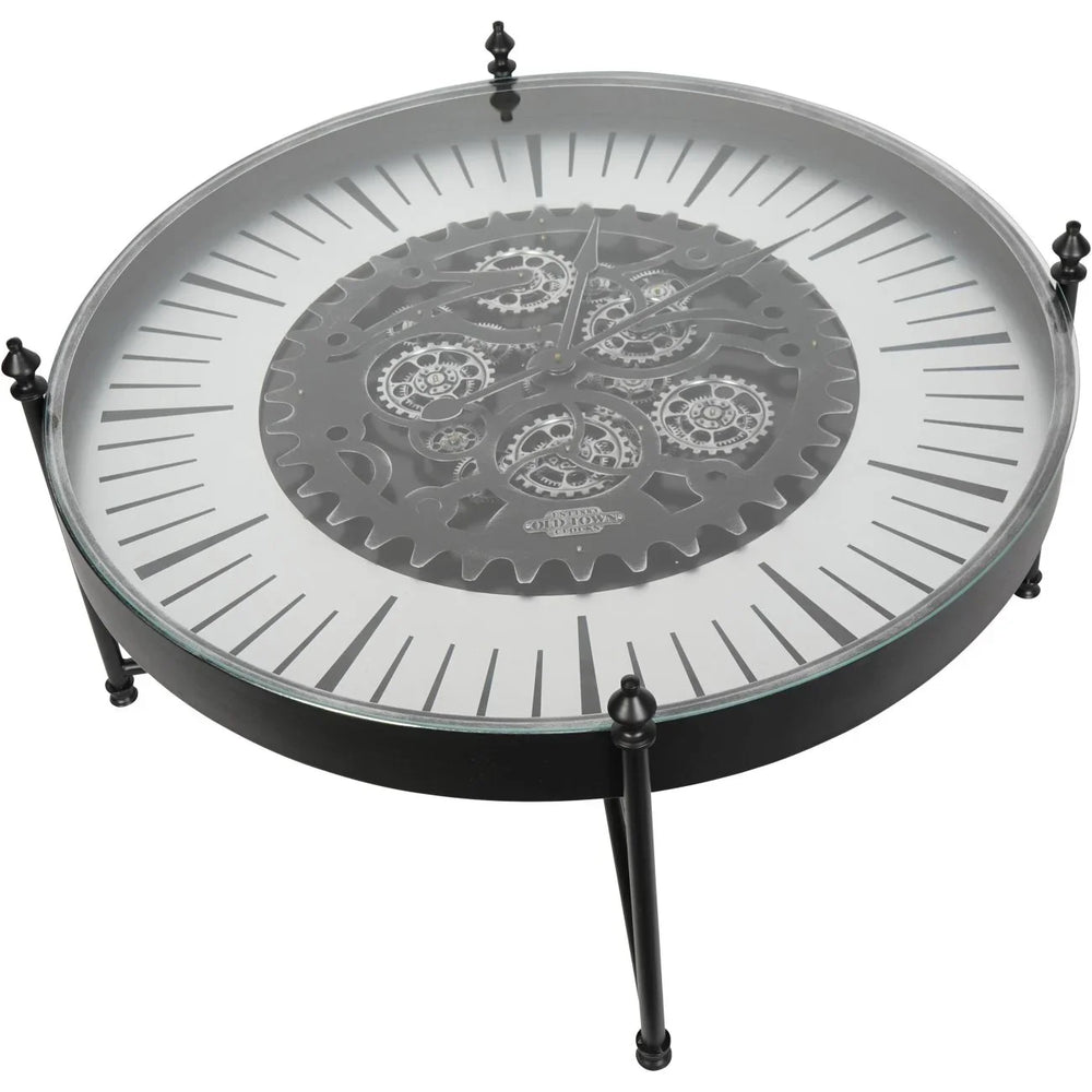 Round clock table with visible cogs and black metal legs.