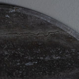 Dark travertine surface with natural stone texture detail.