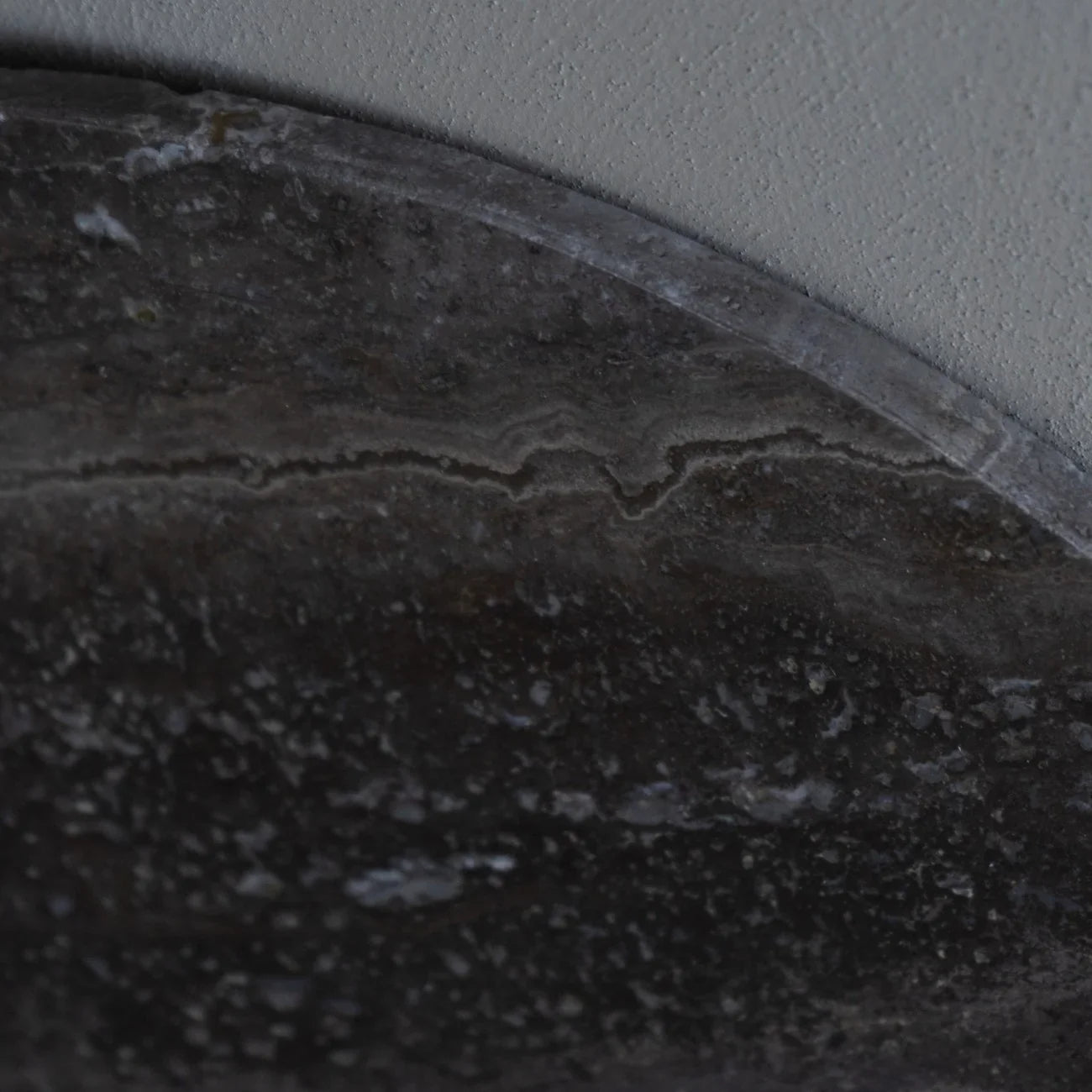 Dark travertine coffee table surface with natural stone texture.