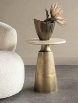 Bronze base side table with travertine top, styled with decorative vase.