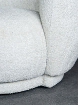 Cream sofa corner with textured fabric detail on a dark floor.