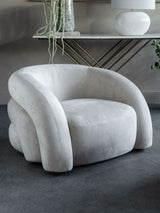 Cream upholstered chair in a modern room with a console table.