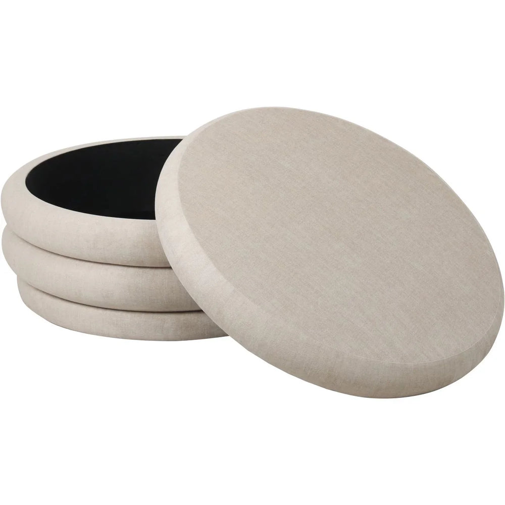 Cream fabric ottoman with open lid showing interior storage space.