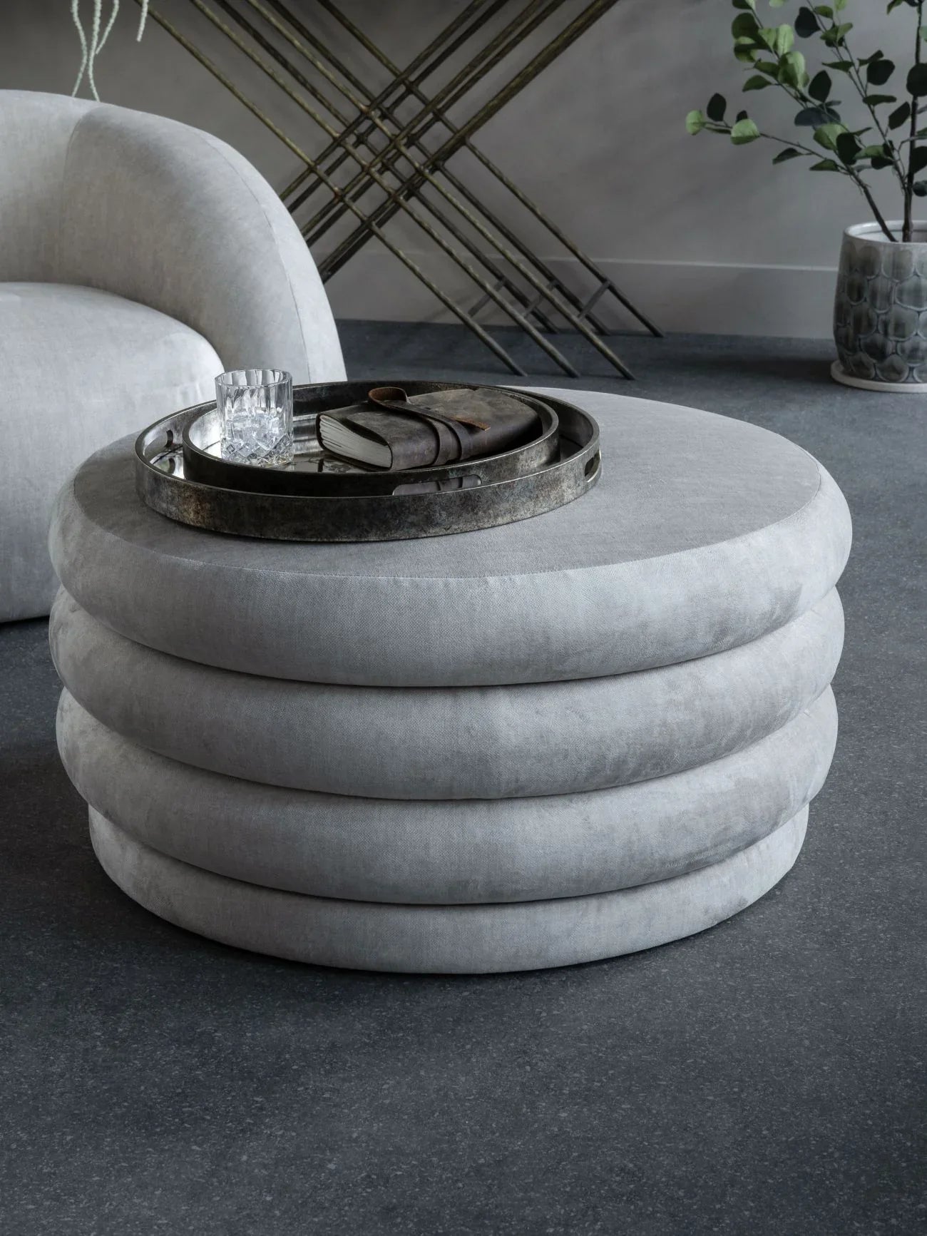 Cream ottoman with layered design in modern living room setting