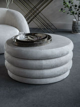 Cream ottoman with layered design in modern living room setting