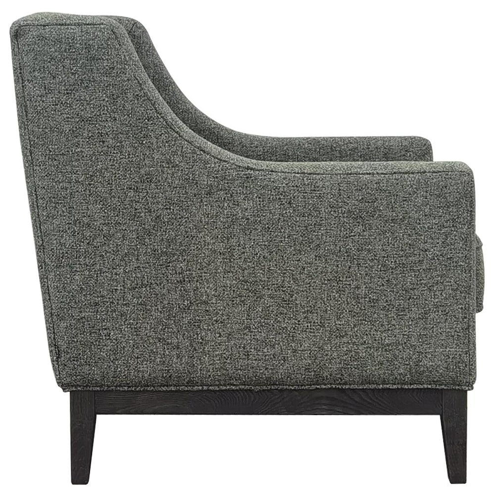 Forest green armchair side view with textured upholstery and dark wooden legs.