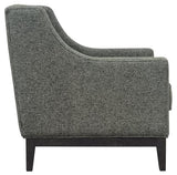 Forest green armchair side view with textured upholstery and dark wooden legs.